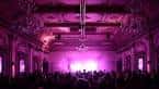 Público en el interior de Bush Hall durante un evento con iluminación escénica violeta