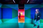 Visita a una sala de exposiciones con paredes de colores y visitantes