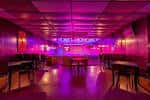 Sala principal del venue con mesas dispuestas para eventos bajo luces púrpuras