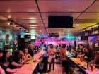 Ambiente social en el interior con barra larga y público congregado
