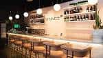 Interior del bar con estanterías de vino y barra iluminada
