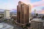 Fachada principal del edificio con cielo nublado y montañas al fondo