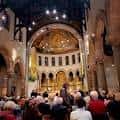 Interior de la catedral durante un evento con congregación y altar iluminado