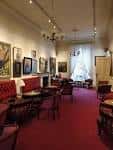 Sala de estar con sofás rojos y cuadros en las paredes