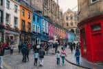 Victoria Street en Edimburgo con edificios de colores vibrantes y gente caminando