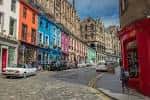 Calle empedrada de Victoria Street con fachadas coloridas y un coche clásico blanco