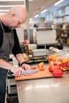 Cocina comercial compartida con chef preparando alimentos