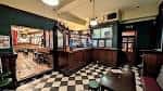 Interior del pub The Fenton mostrando barra de madera, suelo a cuadros y ambiente tradicional