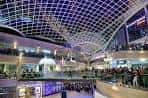 Interior del centro comercial Trinity Leeds mostrando el techo de cristal y la iluminación nocturna
