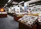 Interior de la tienda mostrando secciones de música y clientes explorando los discos