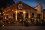 Fachada exterior de Bigsby's Folly iluminada por la noche