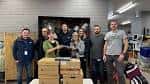 Grupo de voluntarios posando frente a cajas de tecnología donada dentro del espacio del Remakery