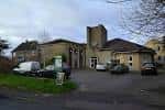 Vista exterior de All Hallows Church en Leeds con su fachada moderna y aparcamiento