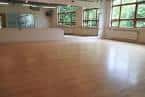 Sala de baile o estudio con suelo de madera y grandes ventanales