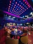 Interior del restaurante WU con iluminación de techo en colores y mesas dispuestas para eventos