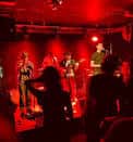 Concierto en el interior de The Waiting Room bajo luces rojas