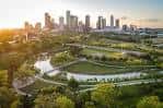 Vista aérea del parque con zonas verdes y curvas del río bajo la luz del atardecer