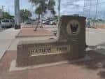 Entrada del Harmon Park con letrero de piedra y logo
