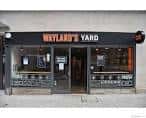 Fachada exterior de Wayland's Yard con letrero negro