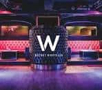 Barra central del Why Not Nightclub con logotipo 'W' y asientos rojos
