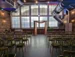 Interior del espacio preparado para un evento con sillas y decoración