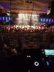 Interior del club con una multitud de personas disfrutando de la música y luces de escenario