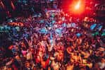Escena vibrante dentro del Ocean Nightclub con gente bailando bajo luces de colores