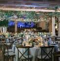Salón de eventos decorado con luces y mesas para una boda