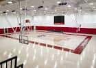 Pista deportiva interior con líneas rojas y canastas bajo iluminación artificial