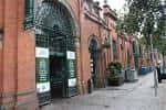 Fachada exterior del St. George's Market con arquitectura de ladrillo rojo y arcos verdes