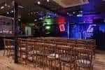 Interior del club de comedia con sillas vacías y escenario iluminado