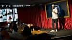 Escenario del club de comedia con un artista en vivo y cortinas rojas