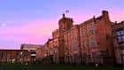 Fachada lateral del edificio escolar al atardecer con cielo rosado