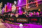 Vista nocturna de la fachada del nightclub Fusion con iluminación y público en la entrada