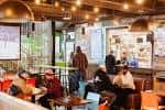 Interior del Graze Food Hall con comensales y puestos de comida