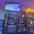 Interior del bar mostrando las estanterías de botellas y una pantalla de televisión