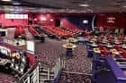 Interior del salón de bingo con asientos rojos y mesas de juego