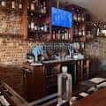 Vista del mostrador del bar con estantería de botellas