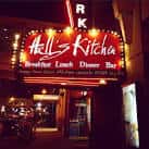 Fachada nocturna con letrero luminoso de Hell's Kitchen