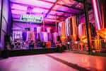 Interior del local Signature Brew con iluminación de concierto y tanques de cerveza al fondo