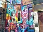 Fachada exterior del pub decorada con murales coloridos y arte callejero