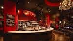 Bar principal con iluminación elegante y decoración roja