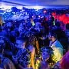 Multitud bailando en el interior del Dalston Den bajo luces azules y rojas