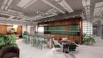 Área de coworking con mesas altas y decoración verde