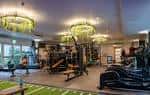 Interior del gimnasio moderno con equipamiento deportivo y lámparas de araña