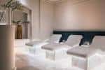 Sala de descanso del spa con camas blancas y decoración minimalista