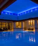 Piscina interior iluminada con luces azules y ambiente relajante