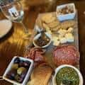 Plato de aperitivos y vino en el interior del establecimiento