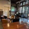 Interior del bar con mesas, sillas y grandes ventanales