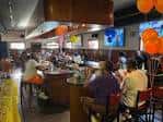 Interior del bar con clientes sentados en el mostrador y decoración festiva